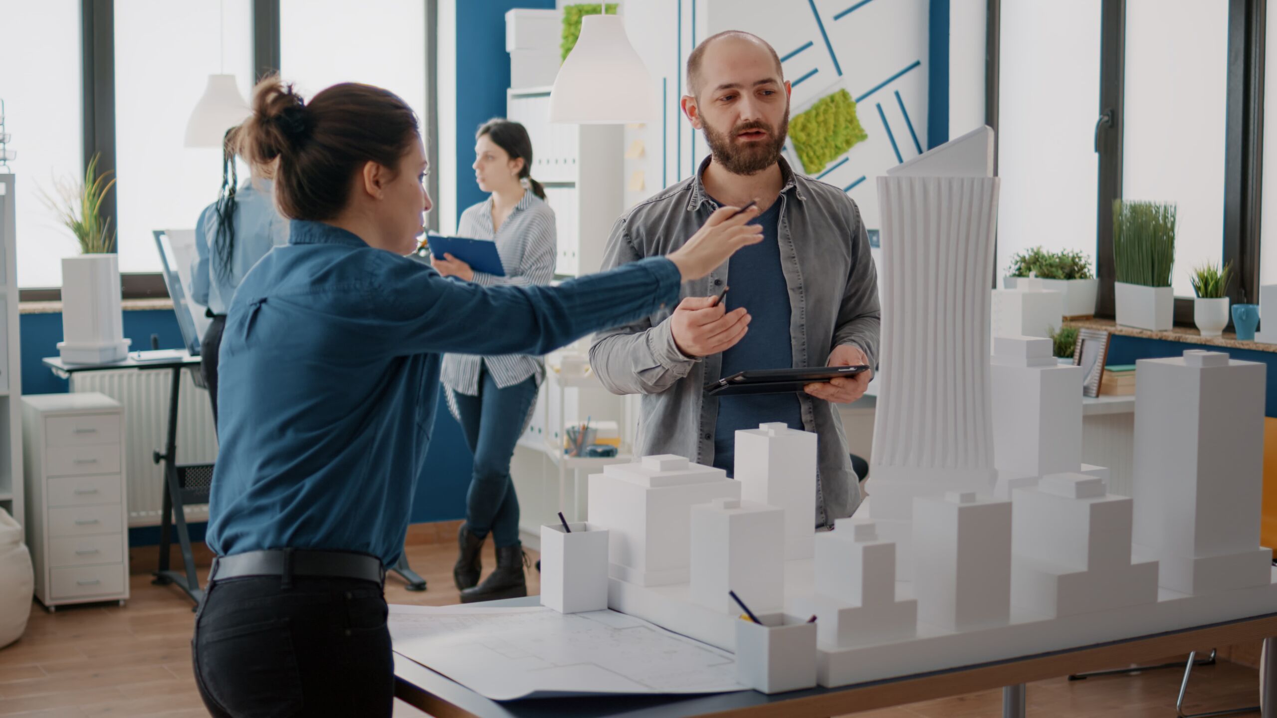 team-coworkers-analyzing-maquette-building-model-plan-construction-tablet-architectural-people-working-together-designing-urban-strategy-real-estate-development (1)